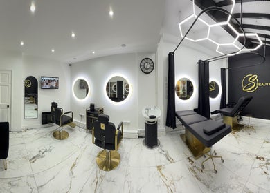 S Beauty Bar in Northampton, England, GB, features chic decor with modern salon chairs and illuminated circular mirrors.