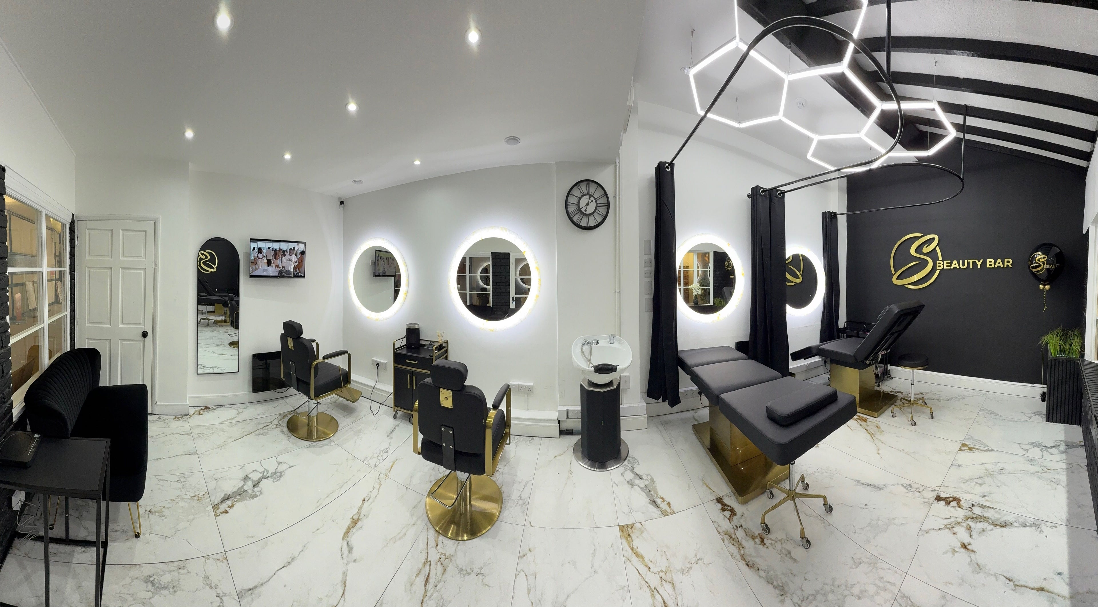 S Beauty Bar in Northampton, England, GB, features chic decor with modern salon chairs and illuminated circular mirrors.