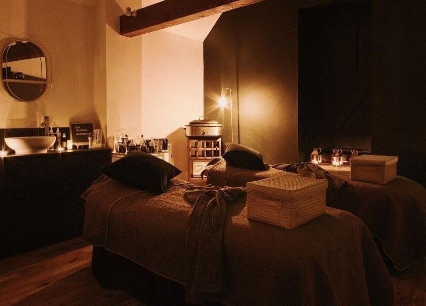 Cozy treatment room at Reading Room Day Spa in Lewes, England, GB, with candle lighting and plush beds.