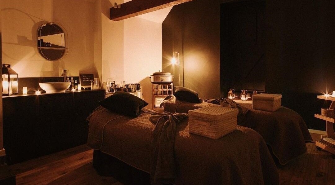 Cozy treatment room at Reading Room Day Spa in Lewes, England, GB, with candle lighting and plush beds.
