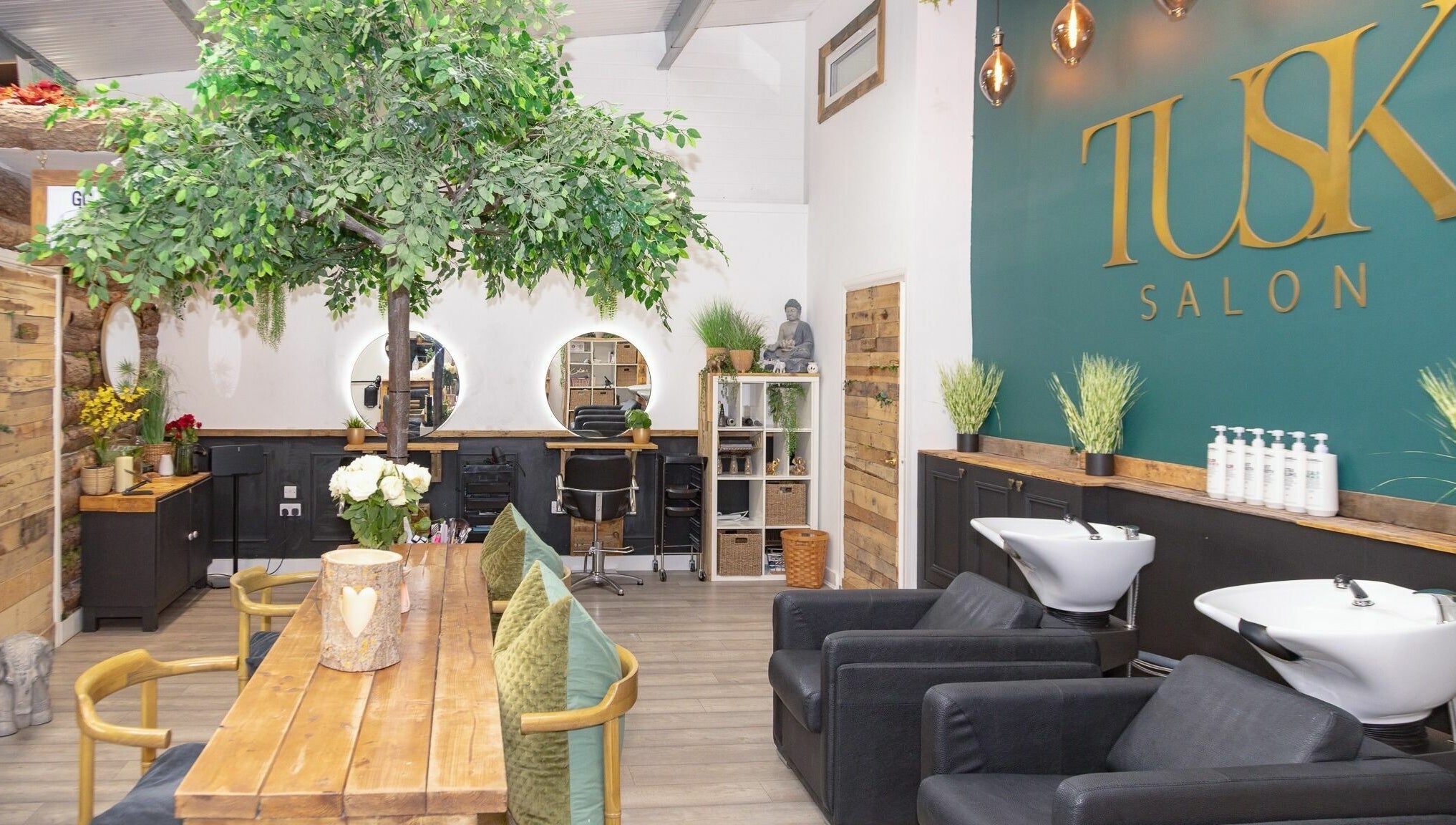 Modern interior of Tusk Salon in Moreton, England, GB, featuring chic decor and lush indoor greenery.