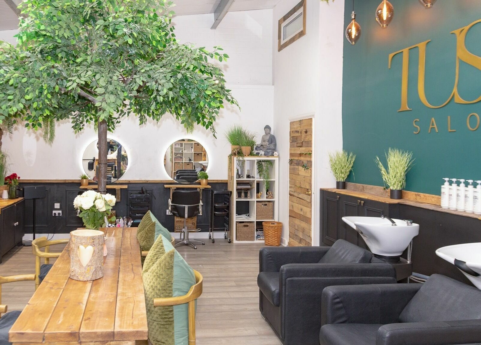 Modern interior of Tusk Salon in Moreton, England, GB, featuring chic decor and lush indoor greenery.