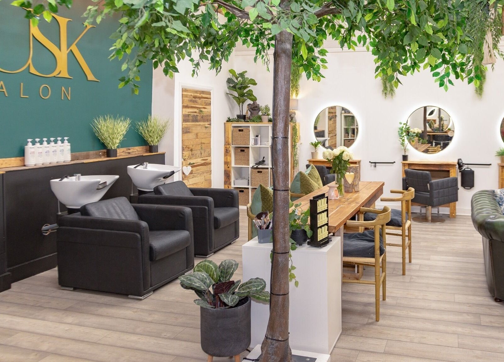 Interior of Tusk Salon in Moreton, England, GB featuring lush plants and styled hair stations.