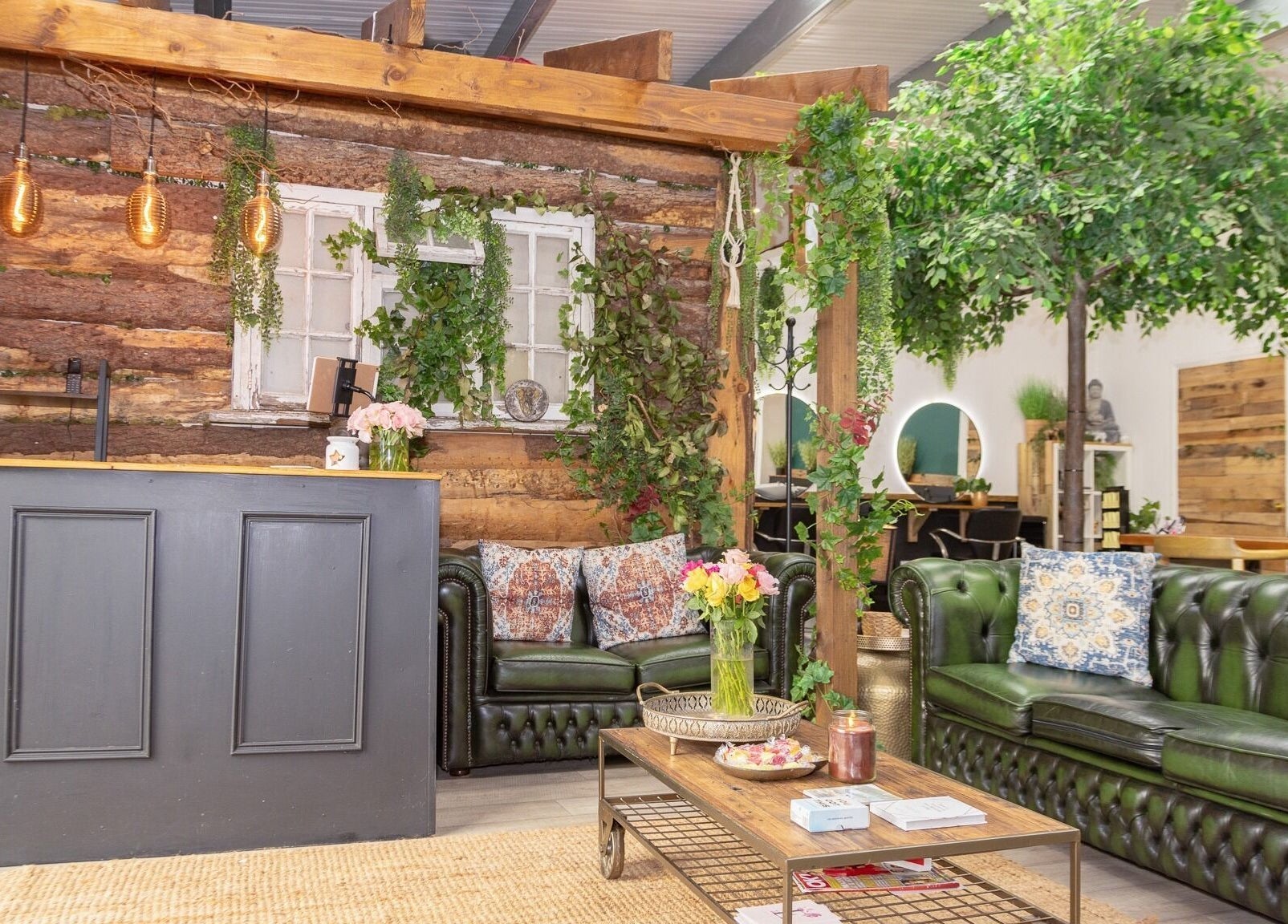 Rustic interior of Tusk Salon, Moreton, England, GB, featuring greenery, vintage decor, and cozy seating.