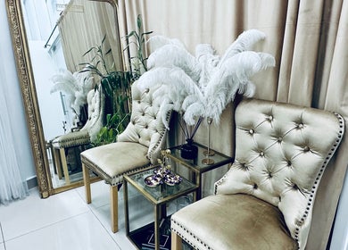 Luxurious seating area at Eyelash Secret Ladies Salon Damac Voleo, Dubai, AE with gold chairs and chic decor.
