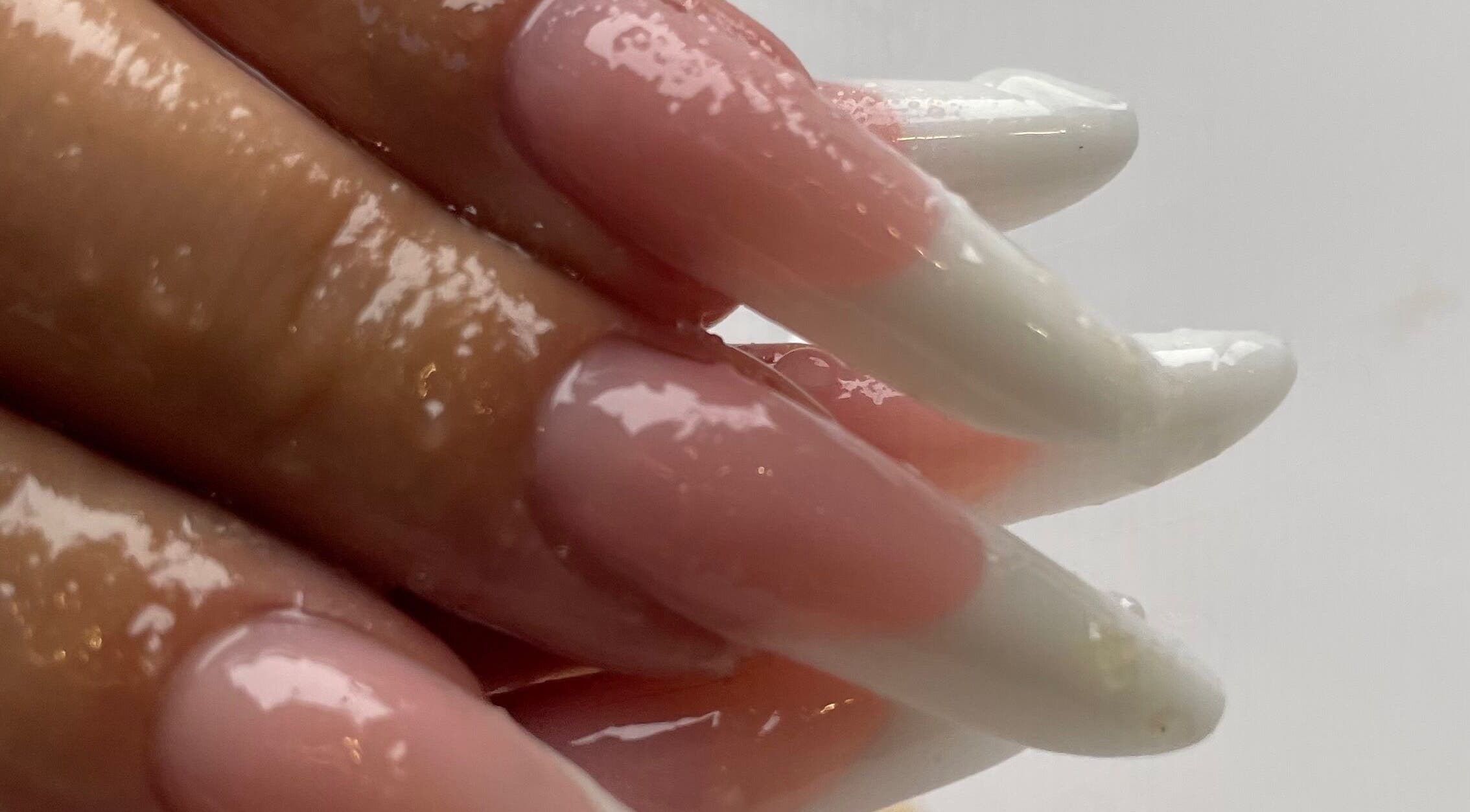 Elegant nail art at Eyelash Secret Ladies Salon Iris Bay, Dubai, Dubai, AE, showcasing glossy pink and white designs.