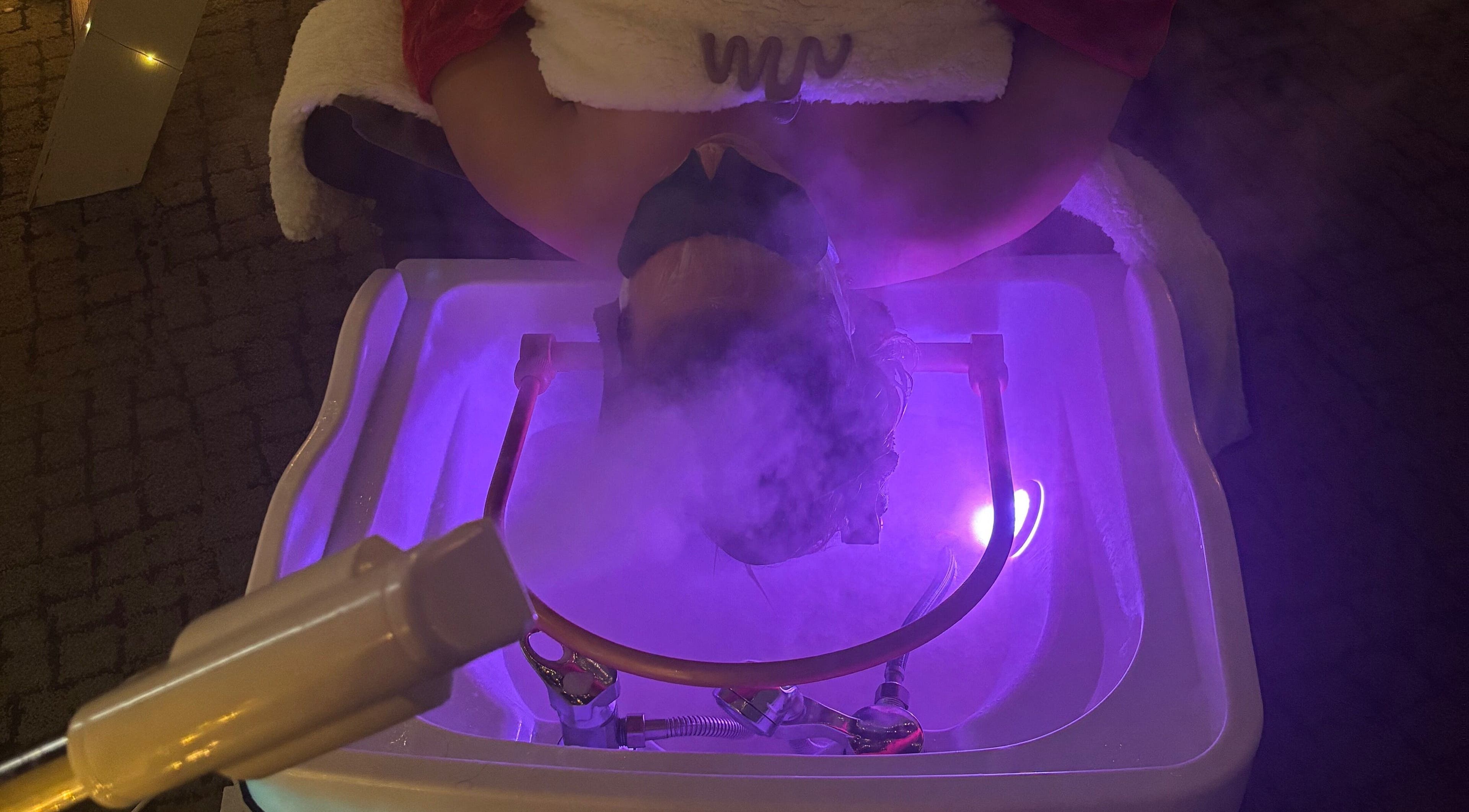 Facial steam treatment at Butterfly Beauty in Wakefield, England, GB under ambient purple lighting.