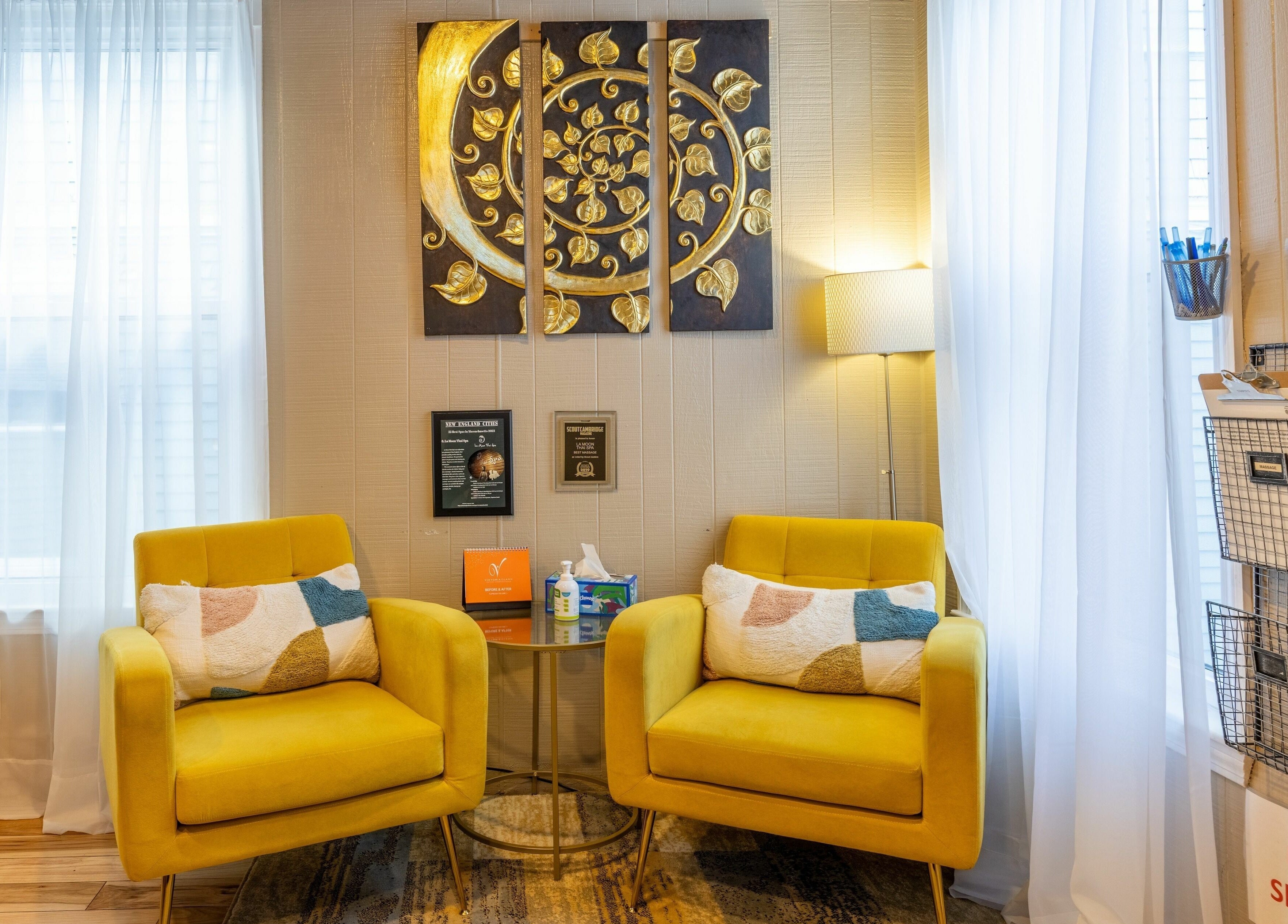 Inviting seating area in La Moon Thai Spa Cambridge, Massachusetts, US with golden decor and plush chairs.