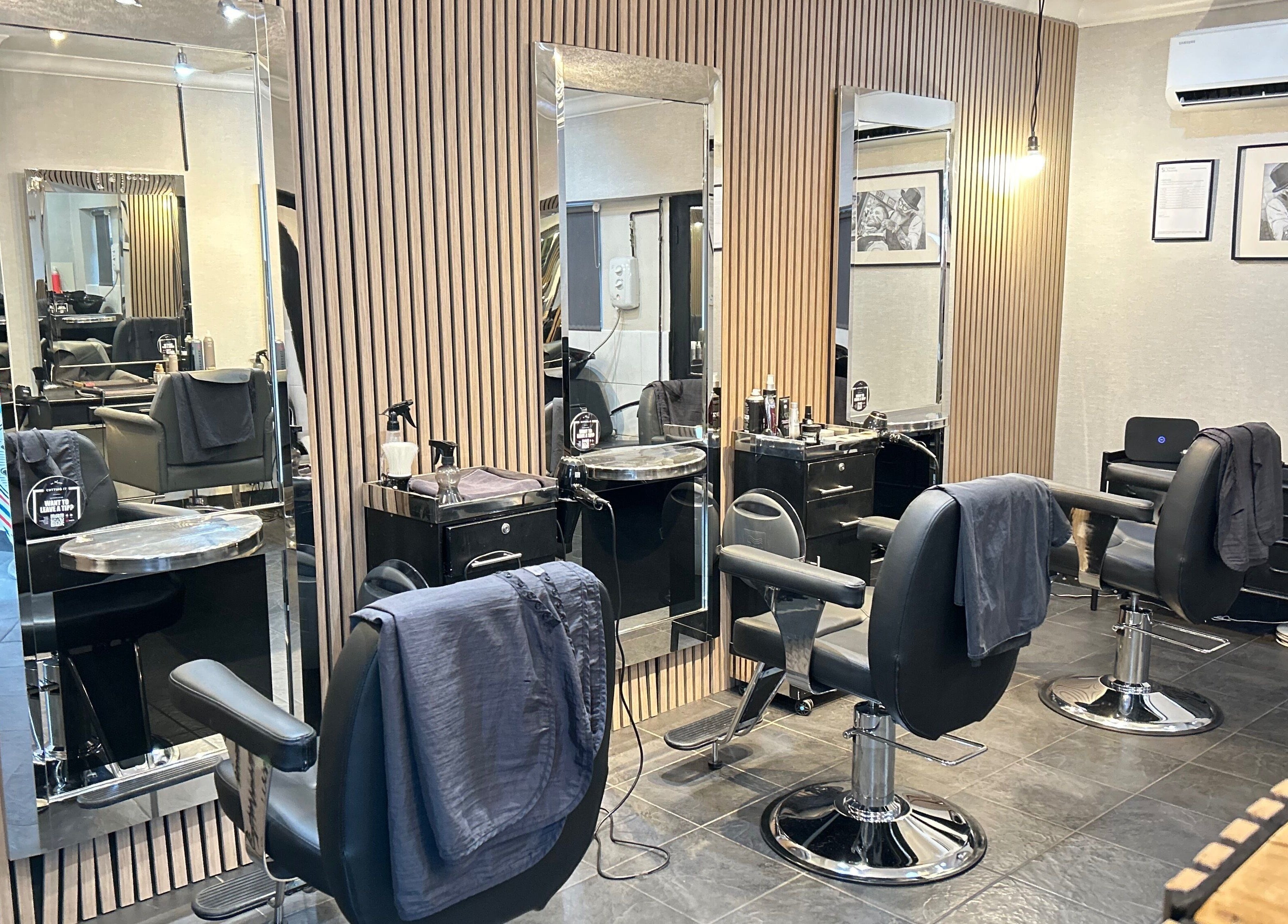 Modern salon interior at Cutting It, Bracebridge Heath, England, GB, featuring sleek styling stations.