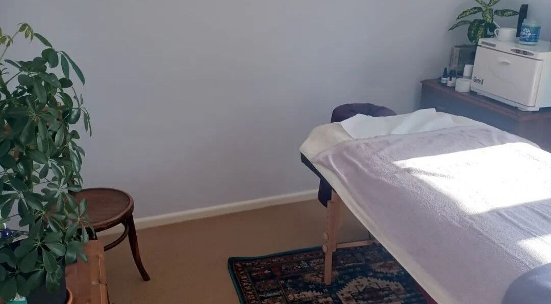 Serene treatment room at Caring For You Treatments in Salwayash, England, GB with a massage table and plants.