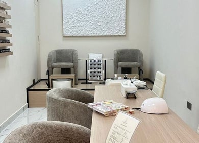 Relaxing nail lounge at Skin Harmony Beauty Salon, Dubai, Dubai, AE, featuring cozy chairs and nail polish wall.
