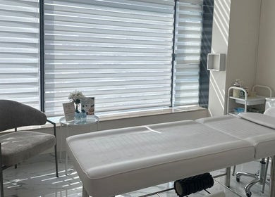 Bright treatment room at Skin Harmony Beauty Salon, Dubai, Dubai, AE with a comfortable massage bed and cozy chair.