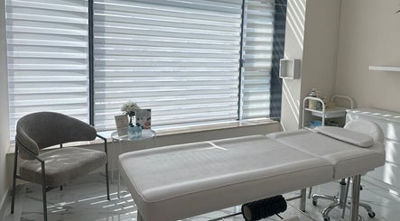 Bright treatment room at Skin Harmony Beauty Salon, Dubai, Dubai, AE with a comfortable massage bed and cozy chair.