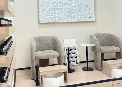Relaxing pedicure station at Skin Harmony Beauty Salon, Dubai, AE with plush chairs and nail polish display.