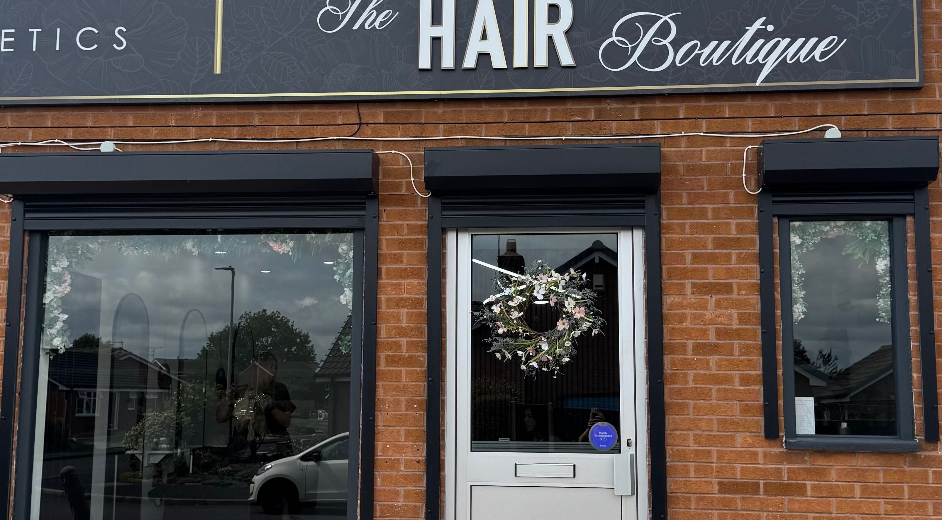 Front entrance of The Hair Boutique in Leeds, England, GB with elegant signage and floral wreath.
