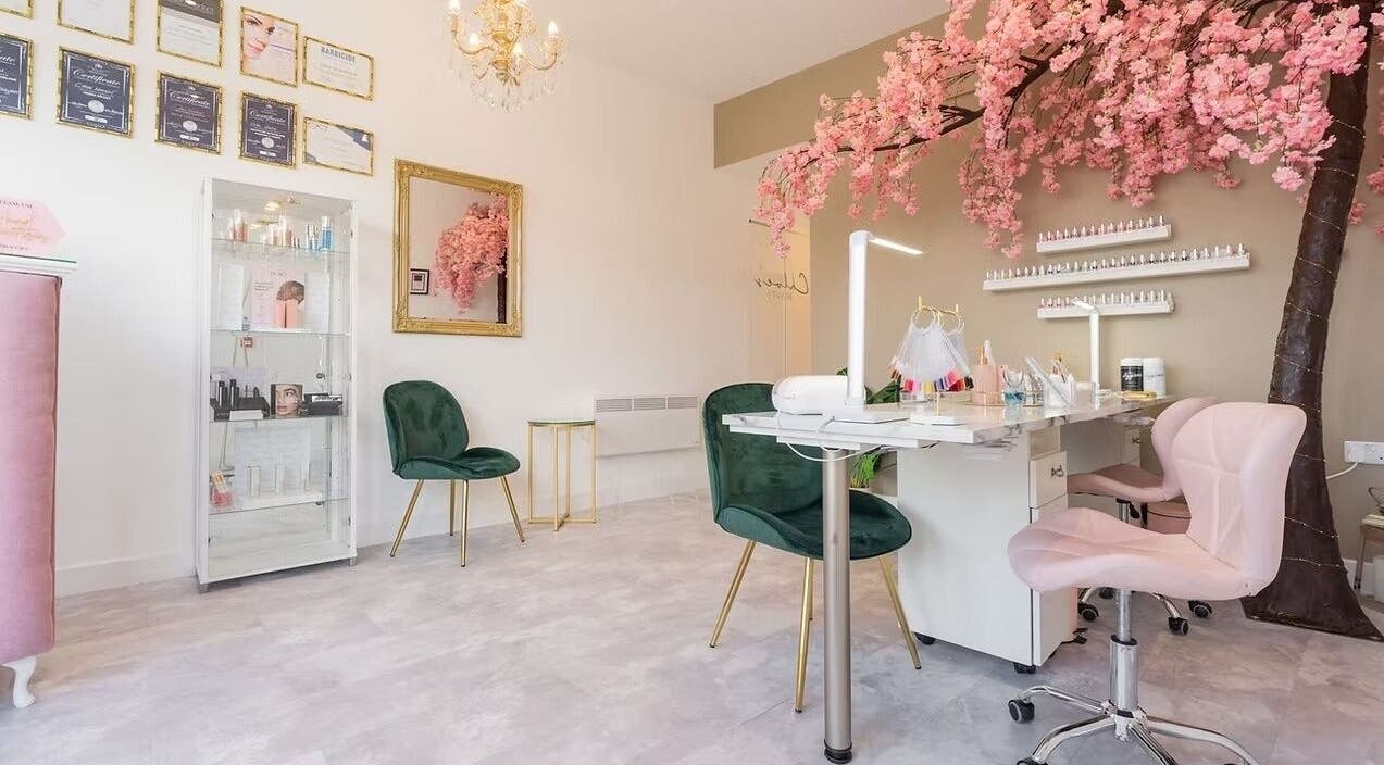 Chloe's Beauty salon in Carlisle, England, GB featuring elegant decor with pink blossoms and chic seating.