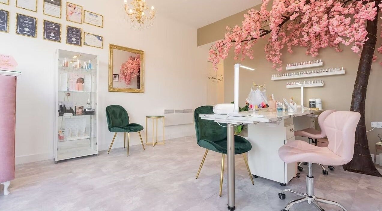 Chloe's Beauty salon in Carlisle, England, GB featuring elegant decor with pink blossoms and chic seating.