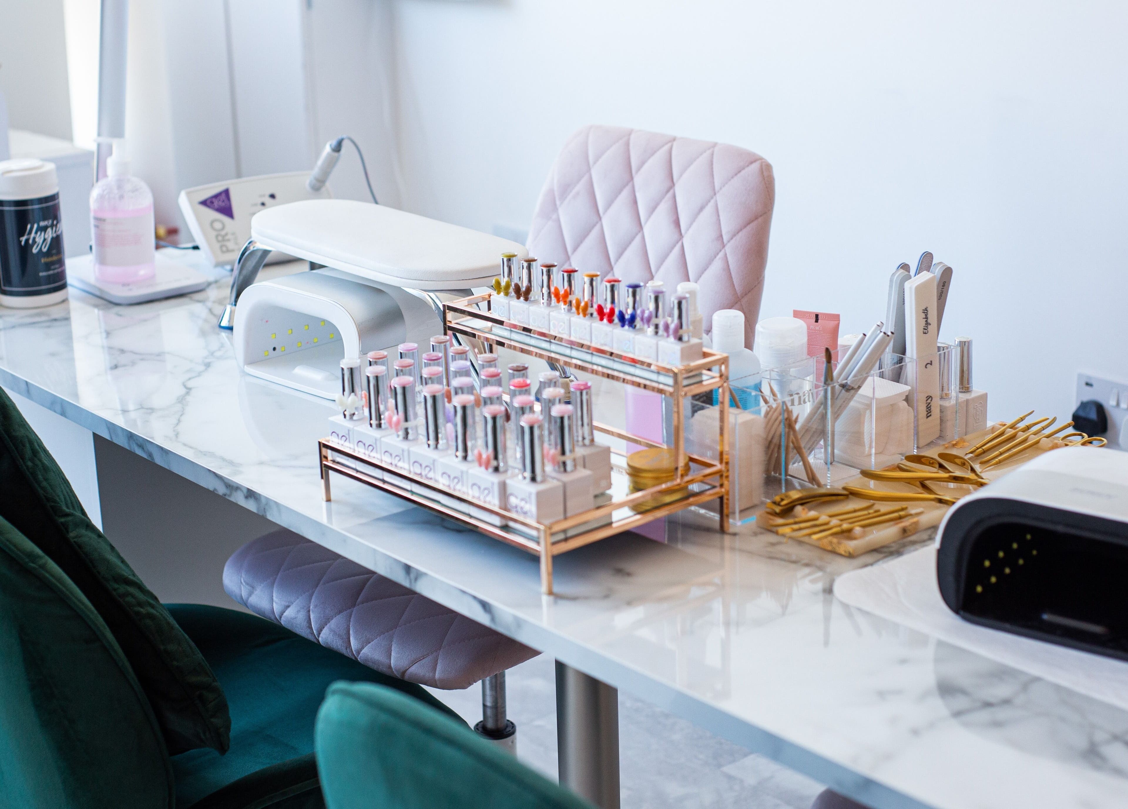Manicure setup at Chloe's Beauty, Carlisle, England, GB with tools and polishes on marble desk.