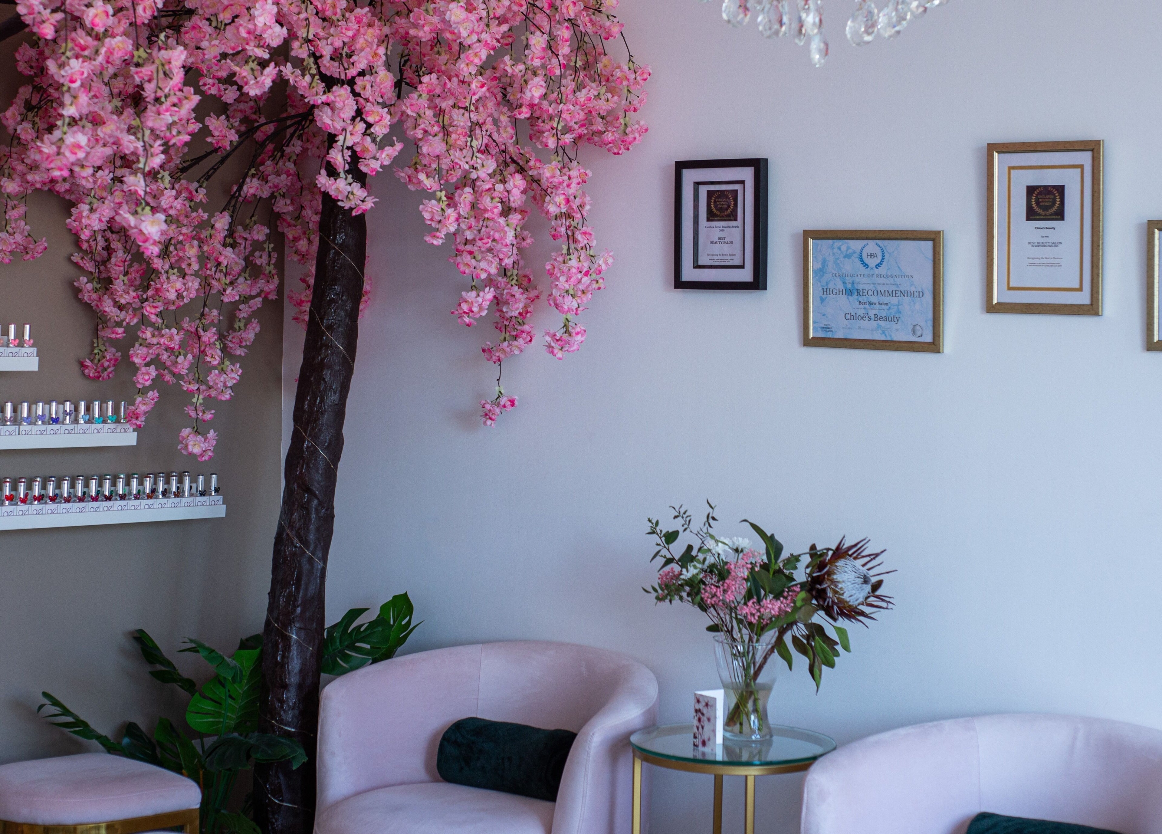 Chloe's Beauty lounge in Carlisle, England with pink blossoms, awards, and nail polish display.