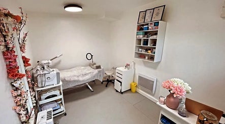 Cozy treatment room at Diaphell Aesthetics in Grays, England, GB with a massage bed and floral decor.