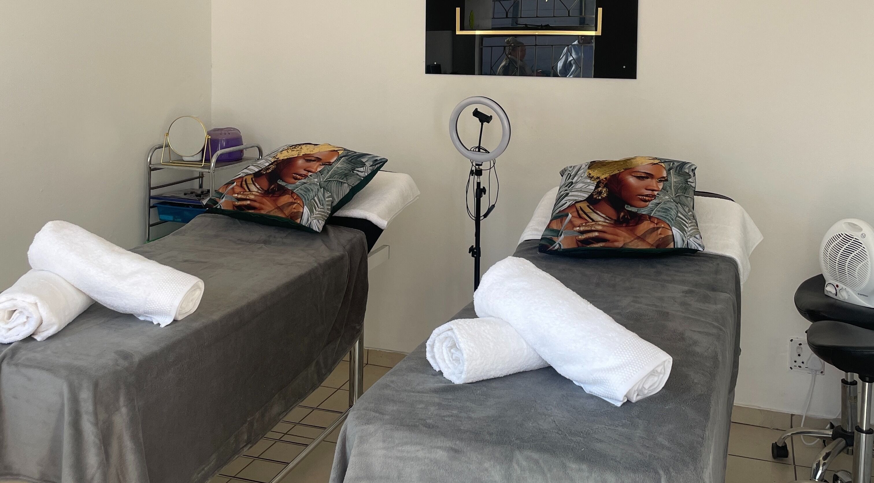 Relaxing treatment beds at GLOSSY Hair and Beauty Studio in Kempton Park, Gauteng, ZA with plush towels.