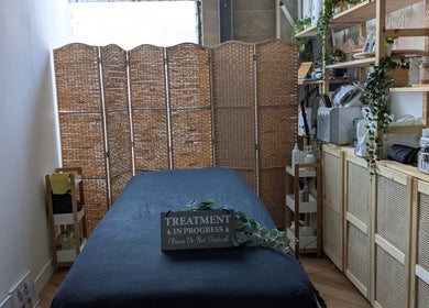Cozy treatment room at Indulge Pamper Relax, London, England, GB. Features massage bed and natural decor.