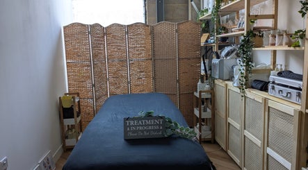Cozy treatment room at Indulge Pamper Relax, London, England, GB. Features massage bed and natural decor.