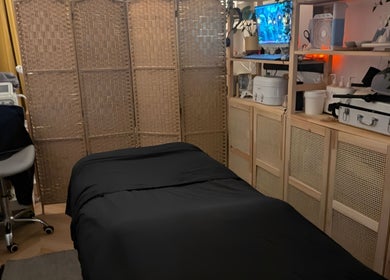 Calm massage room at Indulge Pamper Relax in London, England, GB with a black-covered massage table.