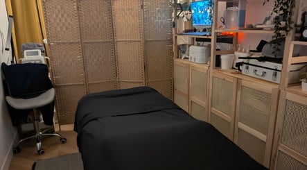 Calm massage room at Indulge Pamper Relax in London, England, GB with a black-covered massage table.