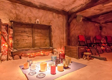Cozy salt room at Praha Spa and Salt, Naples, Florida, US with warm lighting and relaxation chairs.