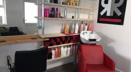 Modern wash station at Julie at Reflections Hair Studio in Hailsham, GB with shelves of hair products.