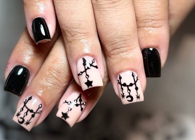 Intricate black nail art at The BeautyVix at Salon V, Leigh, England, GB, showcasing star and moon designs.