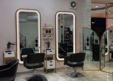 Modern beauty stations at Leen Beauty Center, Sharjah, Sharjah, AE, featuring stylish mirrors and salon chairs.