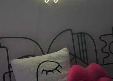 Stylish bed with artistic headboard and pillows at Leen Beauty Center, Sharjah, Sharjah, AE.