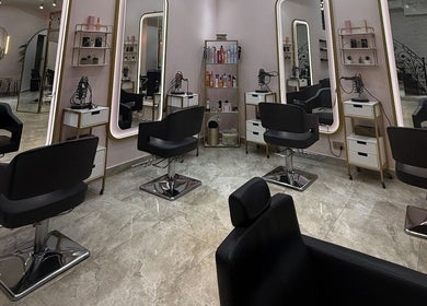 Modern salon interior at Leen Beauty Center, Sharjah, Sharjah, AE featuring sleek styling chairs and illuminated mirrors.