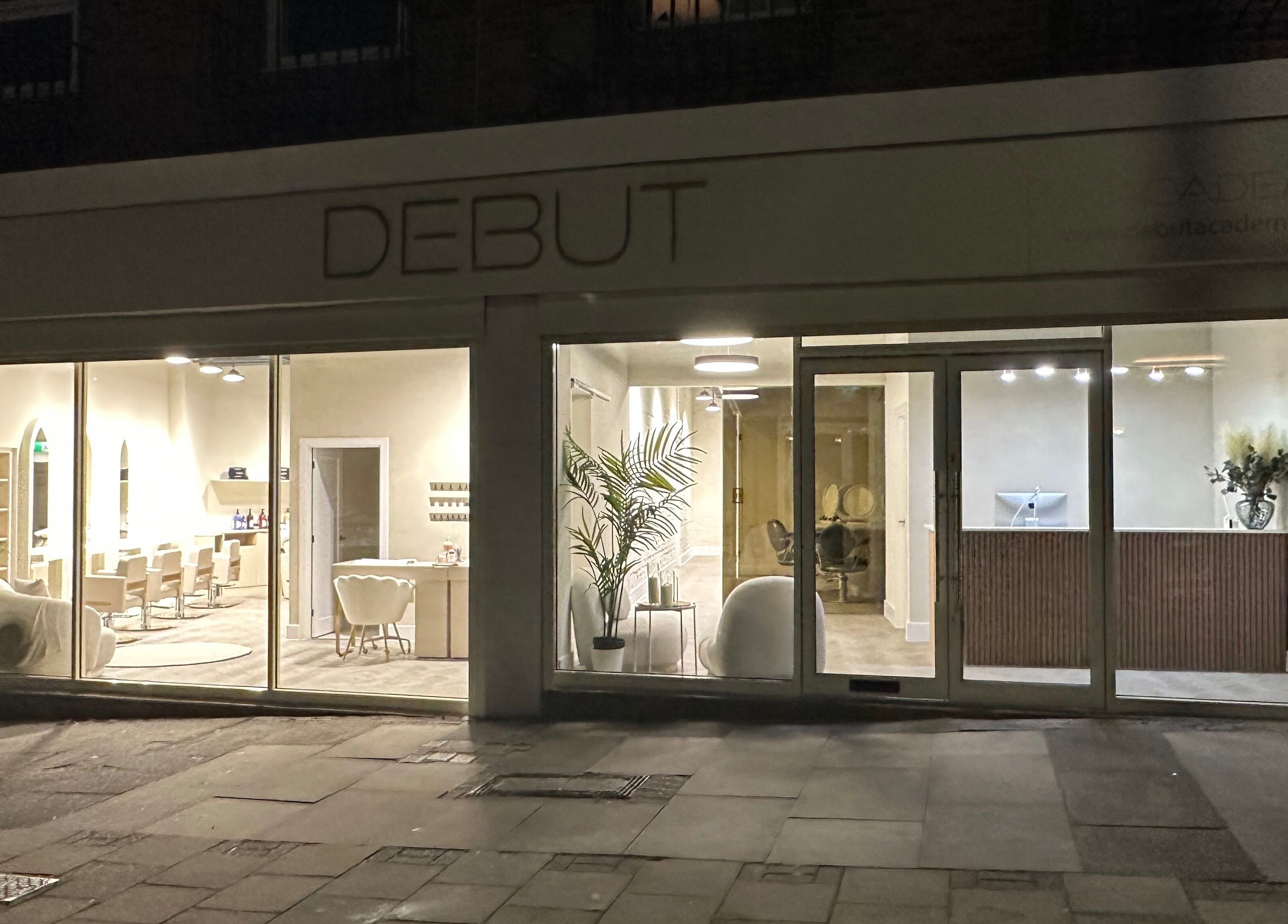 Front view of Debut - Stanford-Le Hope's modern entrance in Stanford le hope, England, GB, glowing warmly at night.