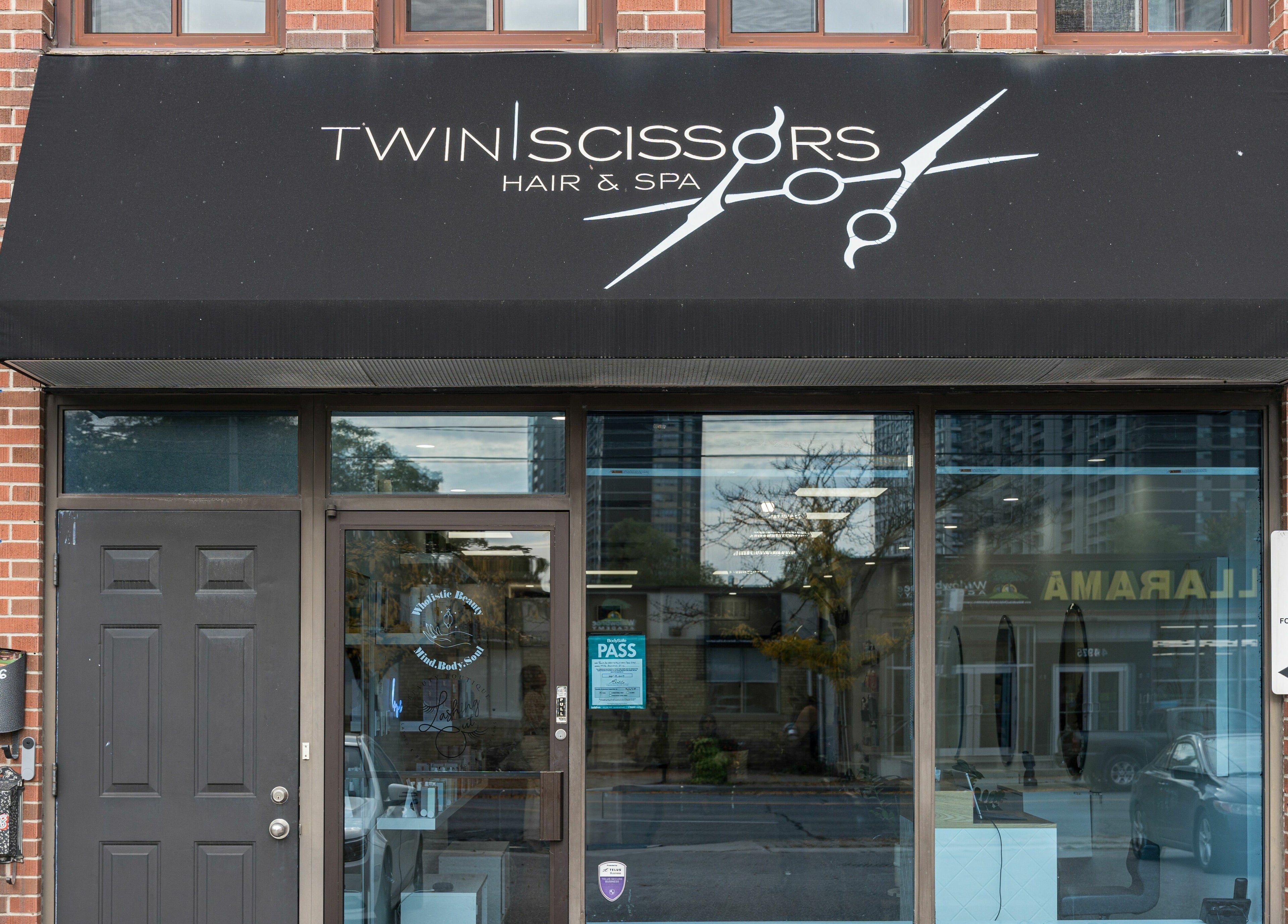Exterior of Twin Scissors in Toronto, Ontario, CA, showcasing its inviting glass facade.