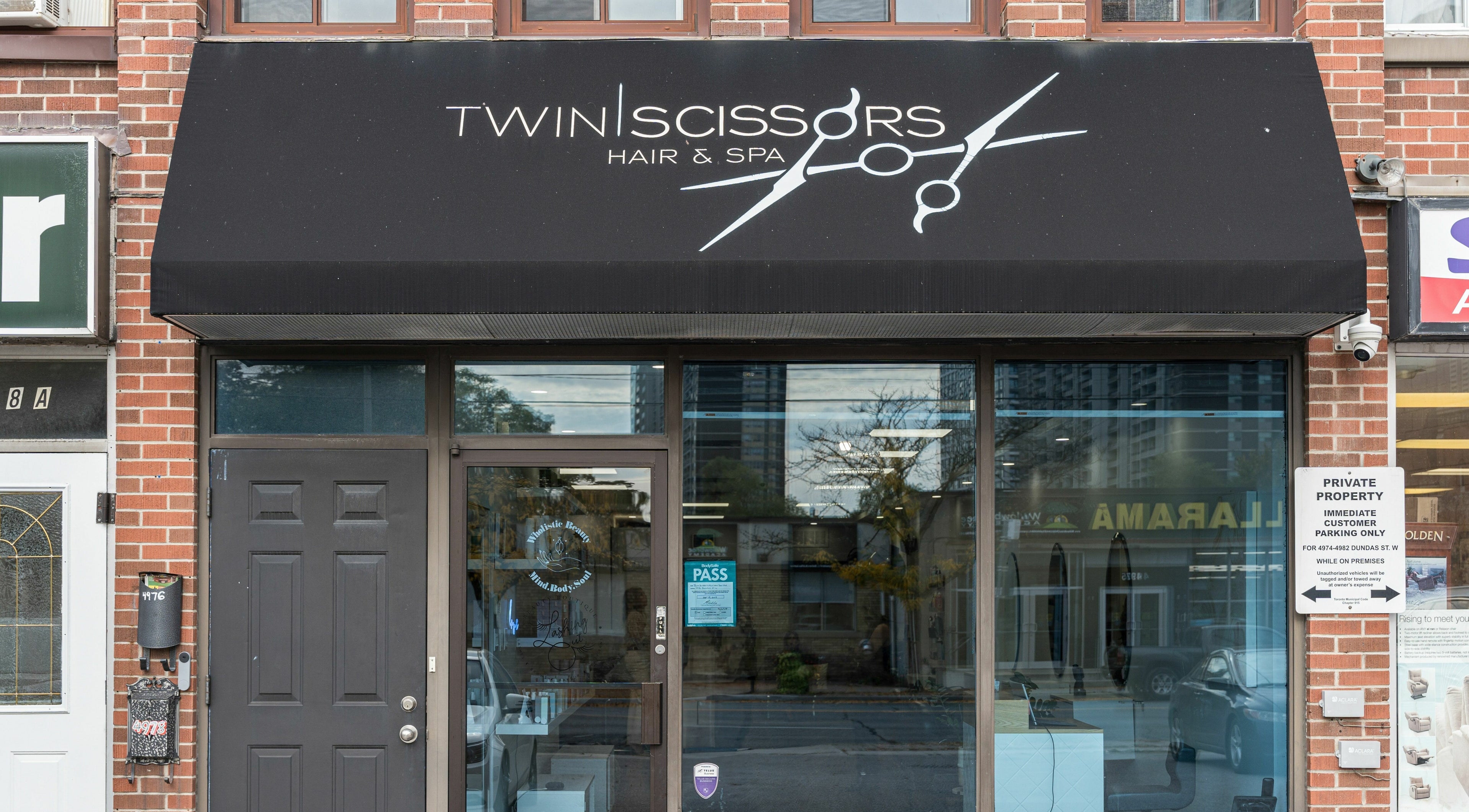 Exterior of Twin Scissors in Toronto, Ontario, CA, showcasing its inviting glass facade.