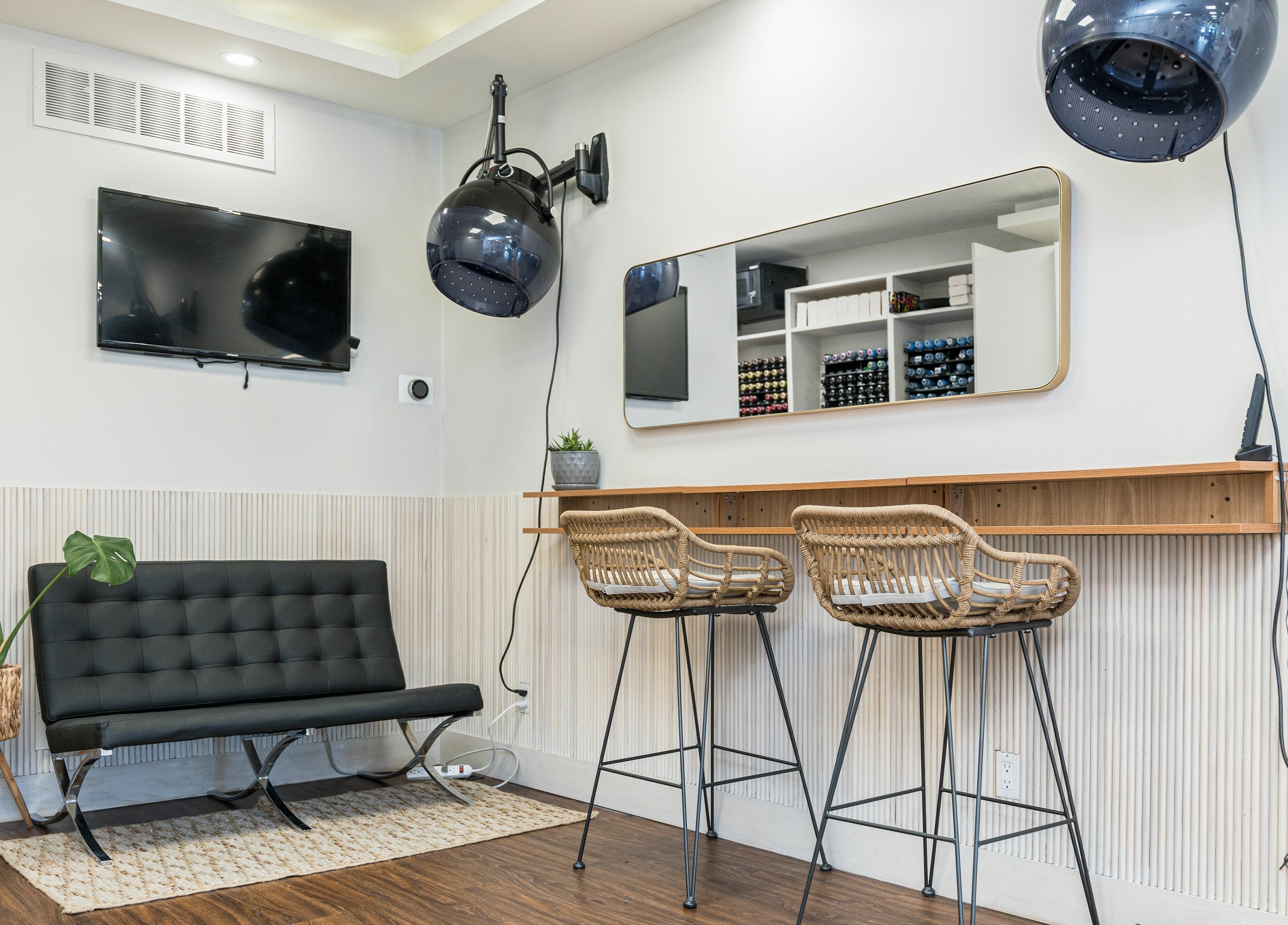 Modern seating area in Twin Scissors, Toronto, Ontario, CA, featuring wicker chairs and a wall-mounted TV.