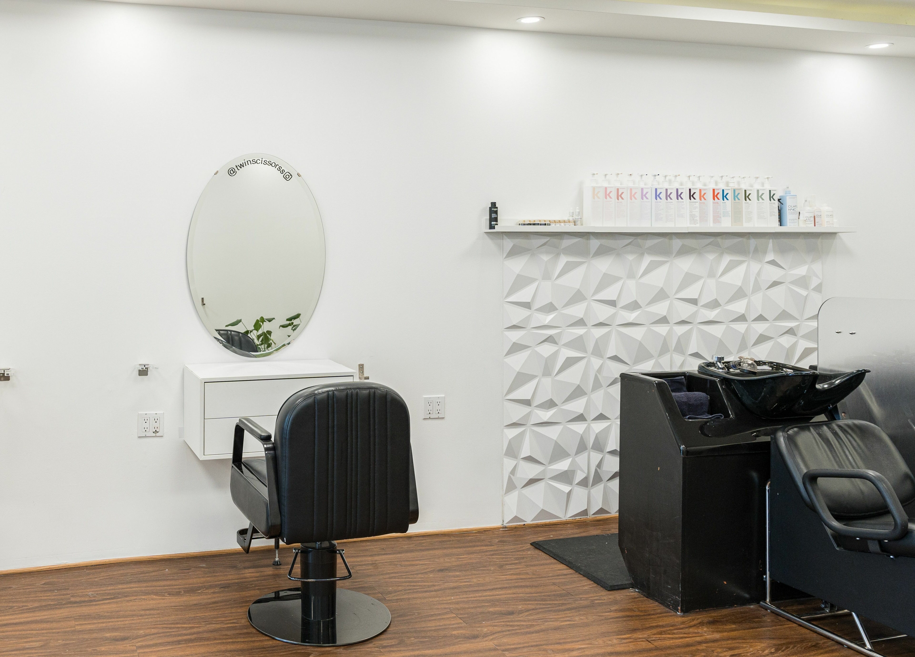 Modern hair salon interior at Twin Scissors, Toronto, Ontario, CA, featuring sleek chairs and stylish mirrors.