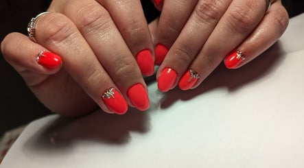 Vibrant red manicured nails with gem accents at Marta's Beauty Lounge, Burton Upon Trent, England, GB.