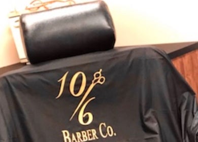 Black barber chair with logo at 10/6 Barber Company in Belleville, Ontario, CA.