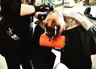 Barbering service at 10/6 Barber Company in Belleville, Ontario, CA. Stylist working meticulously on a client.