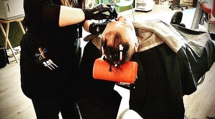 Barbering service at 10/6 Barber Company in Belleville, Ontario, CA. Stylist working meticulously on a client.