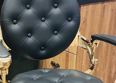 Luxurious barber chair at 10/6 Barber Company in Belleville, Ontario, CA featuring tufted black leather.