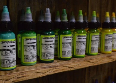 Electrum tattoo inks displayed on a shelf at R.I Studio, Cambridge, England, GB, showcasing a vibrant selection.