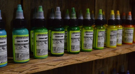 Electrum tattoo inks displayed on a shelf at R.I Studio, Cambridge, England, GB, showcasing a vibrant selection.