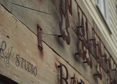 Wooden sign of R.I Studio - Hairdressers, Tattoos & Piercings, Cambridge, England, GB.