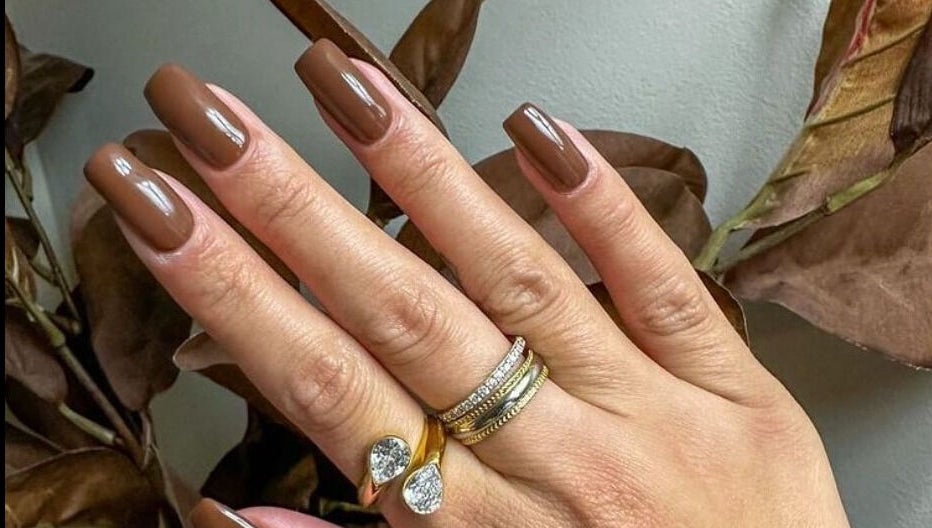 Elegant brown manicured nails at Loven Beauty Inc, Vaughan, Ontario, CA, showcasing chic style and luxury rings.