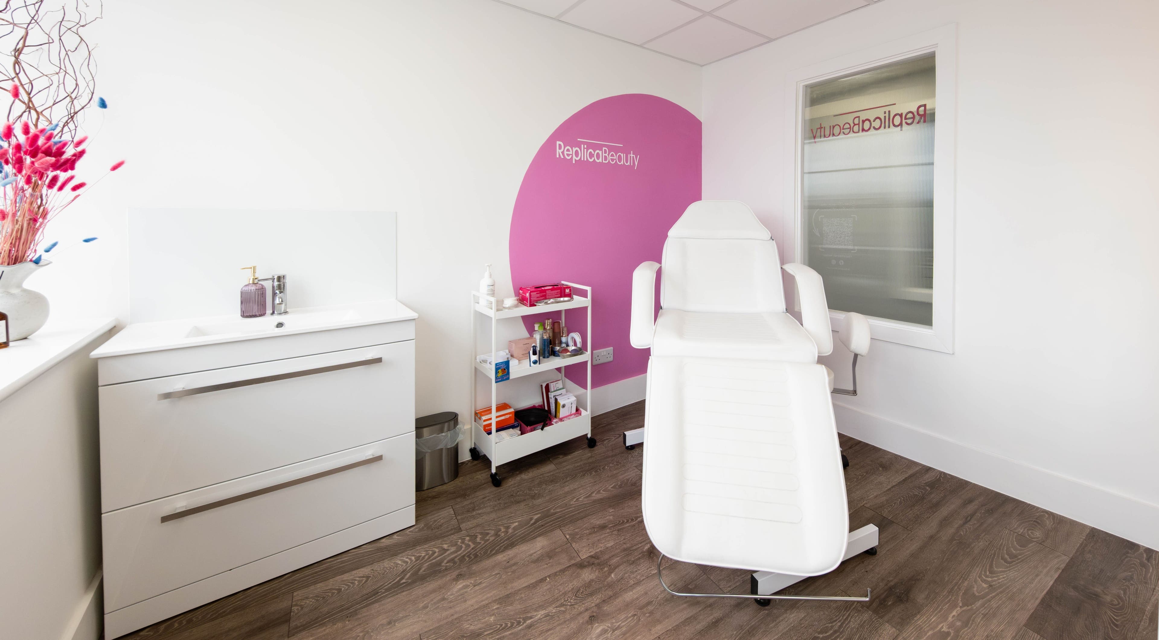 Bright and modern treatment room at Replica Beauty, London, England, GB, featuring a white reclining chair.